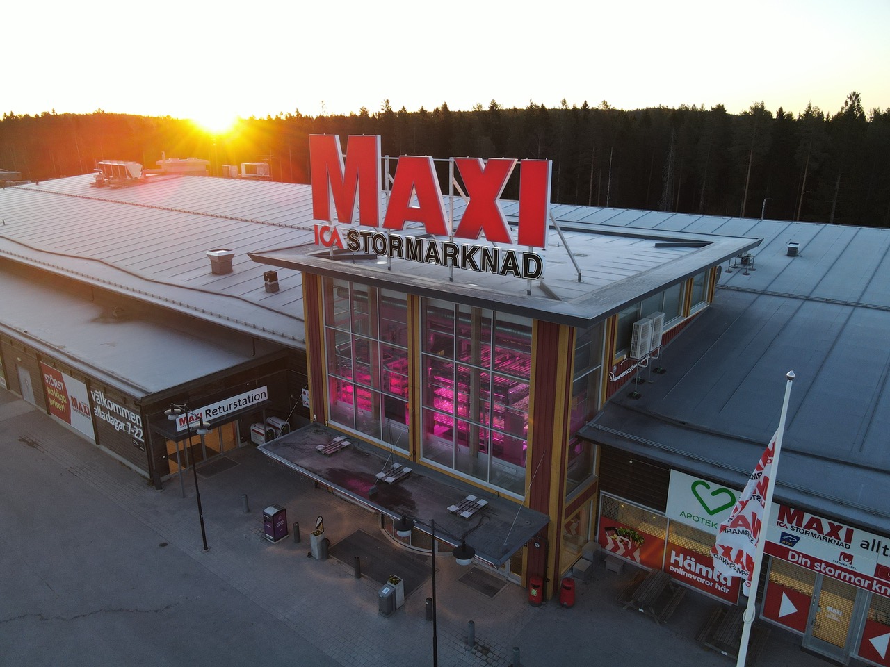 Maxi ICA Stormarknad Skellefteå at sunset, with the entrance tower lit pink by the in-store farm